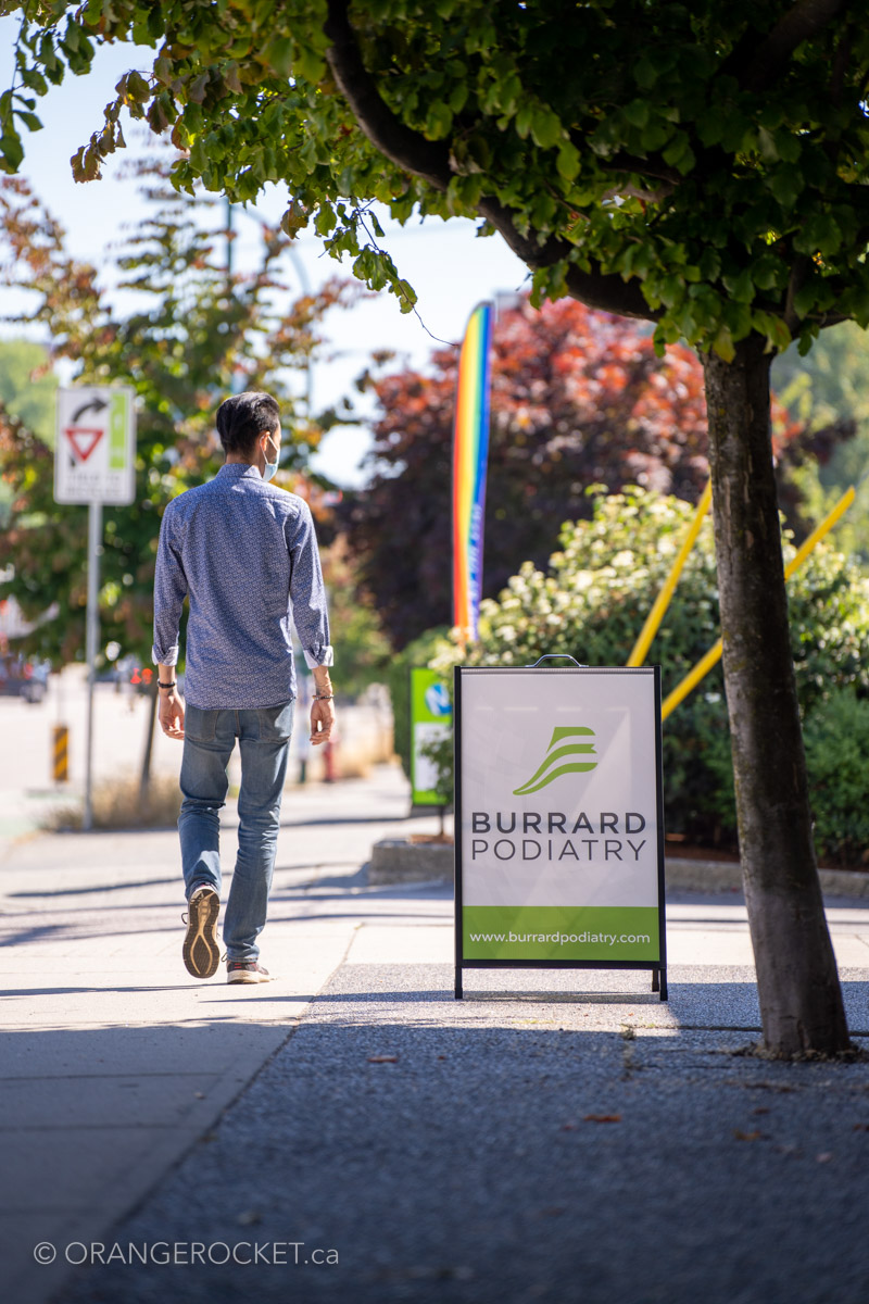 Person walking past the Burrard Podiatry sign