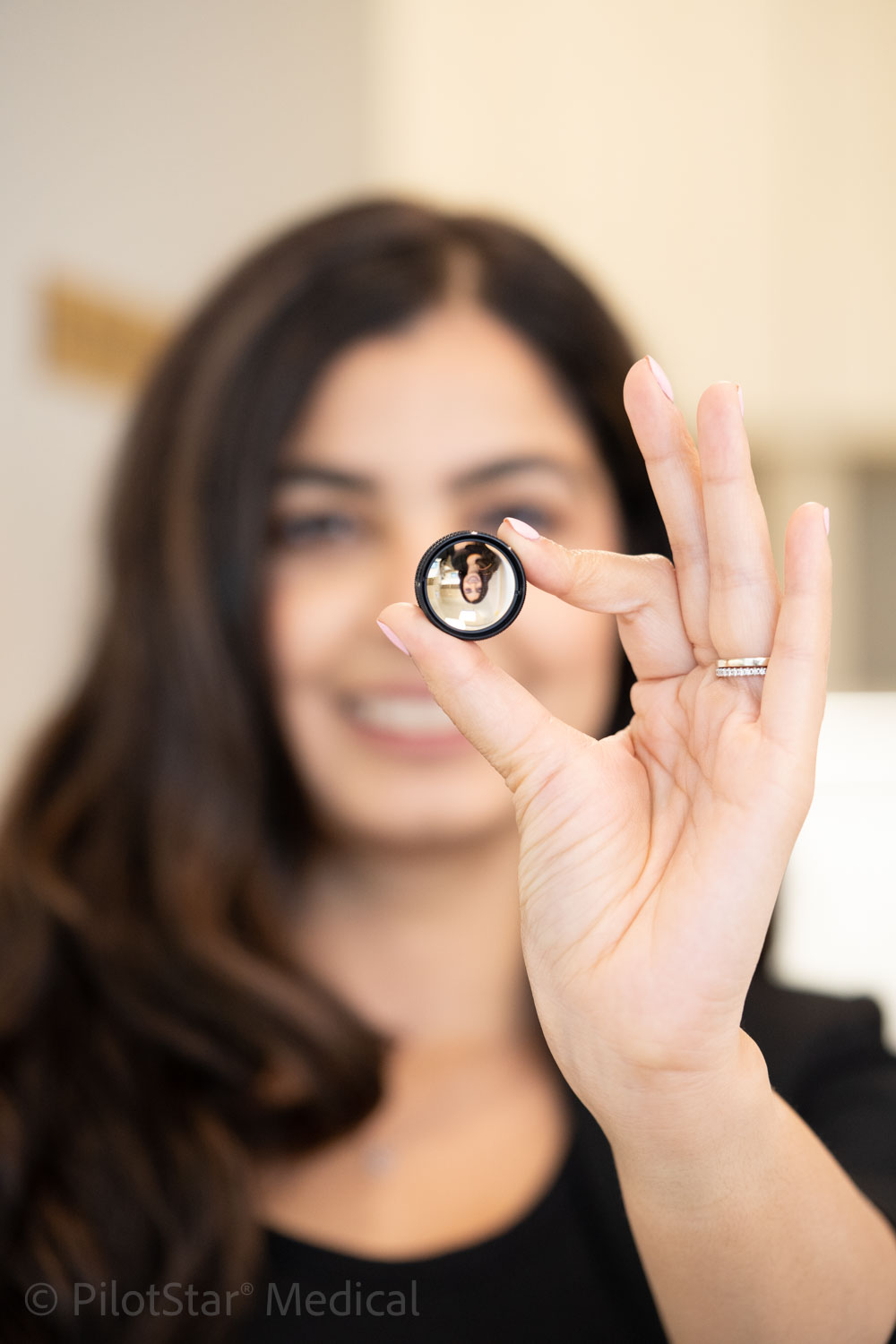 Eye care professional holding an examination lens