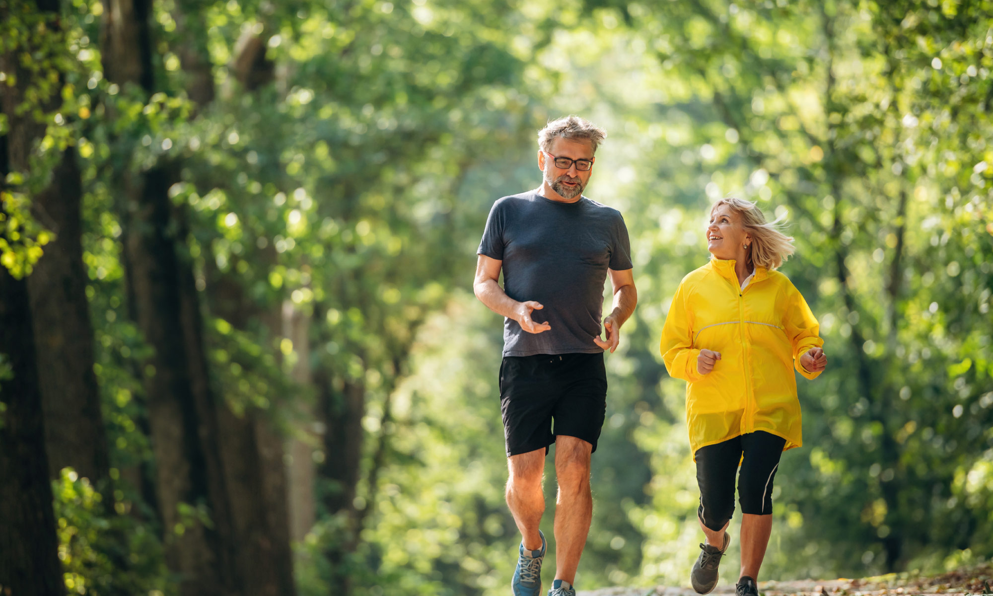 Couple jogging along a wooded path